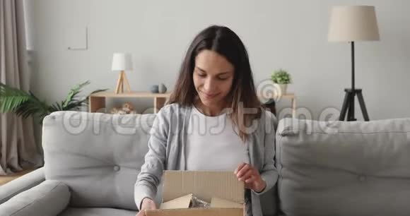 惊讶的年轻女子打开纸板箱与互联网商店的订单视频的预览图
