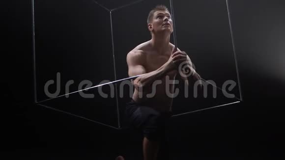 马戏团男性肌肉表演者在黑色背景下用杂耍立方体道具做把戏集中概念视频的预览图