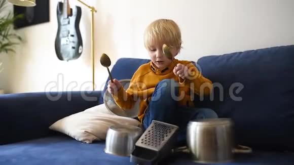 淘气的学龄前男孩使用厨房工具和用具演奏音乐有趣的鼓部分来自小男孩视频的预览图