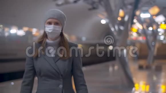 戴着面具走在地铁站的女人视频的预览图
