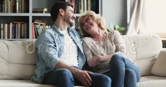 幸福2代家庭谈笑风生坐沙发视频的预览图