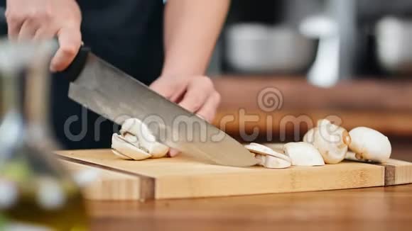 特写专业厨师人员手工将蘑菇切片放在木板上红色相机宽镜头视频的预览图
