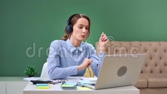 自信的女老师在耳机学习远程制作视频通话笔记本电脑4k龙红相机视频的预览图