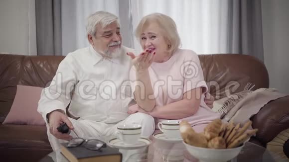 积极成熟的白种人夫妇在晚上爱看电视的肖像快乐的老夫妻休息视频的预览图