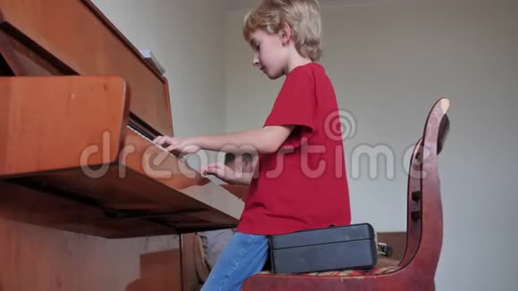 一个八岁的男孩在家弹钢琴视频的预览图