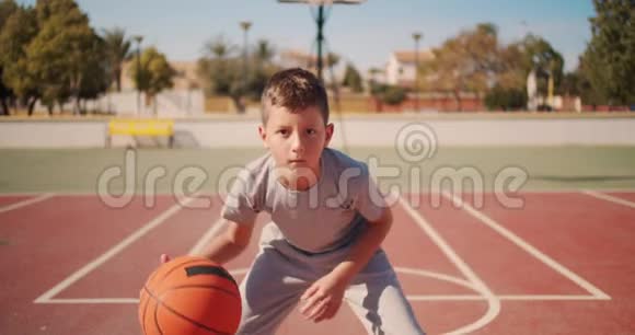 可爱的孩子在玩篮球男孩练习打篮球视频的预览图
