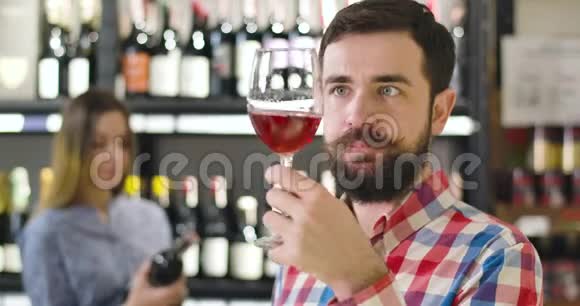 特写专注的白种人男子闻红酒在玻璃和摇动酒杯自信的集中侍酒师视频的预览图