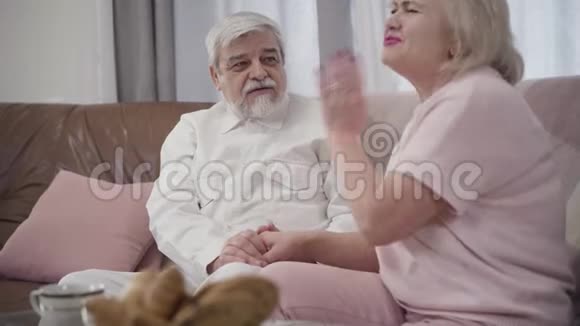 开朗的高加索老人和成熟的女人在家里谈笑风生的肖像快乐的退休夫妇视频的预览图
