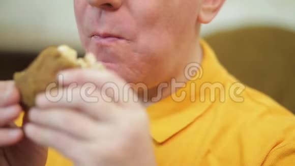 一个有胃口的男人在晚餐时吃汉堡视频的预览图