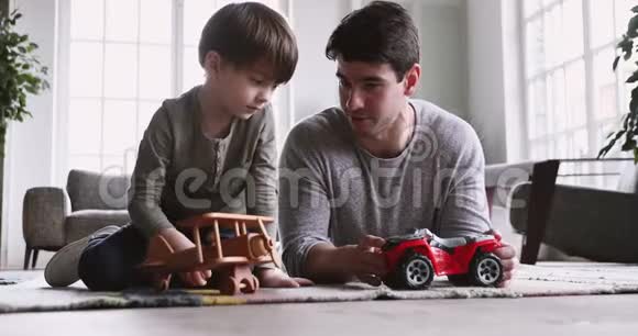 爸爸和可爱的小儿子玩有趣的赛车游戏视频的预览图