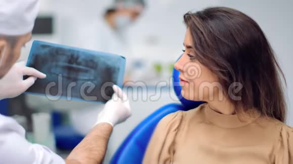 男性牙医显示牙齿x射线口腔状况和治疗4K红色相机拍摄视频的预览图