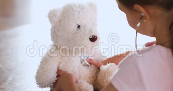 童女扮演医生拿着听诊器听泰迪熊特写视频的预览图