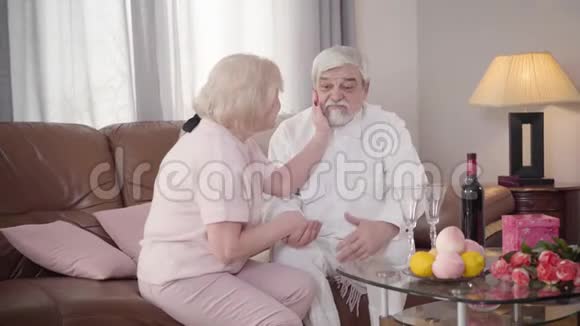 金发白种人成熟的女人摸着丈夫脸年长的白发男人说话已婚退休人员恋爱消费视频的预览图