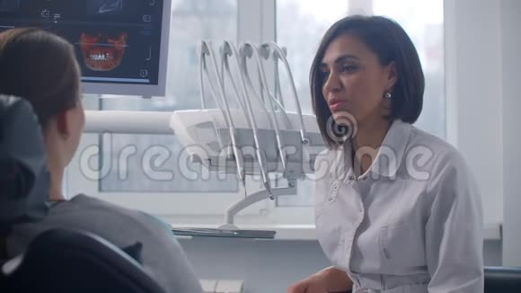 一位女性正畸牙医讨论了一个坐在椅子上的病人的核磁共振扫描视频的预览图