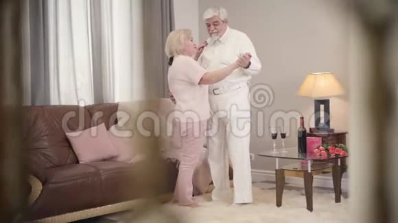 一对成熟的白种人已婚夫妇在家里聊天跳舞快乐的退休老人庆祝圣圣视频的预览图