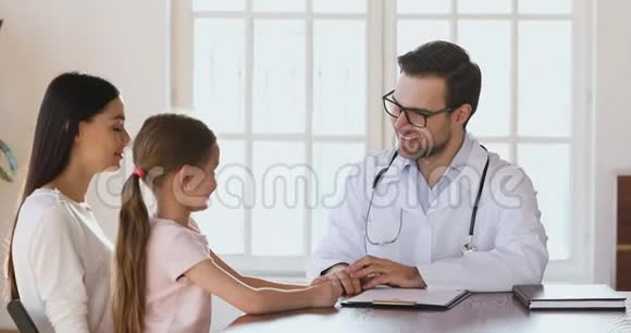 可爱的男医生说话抚摸可爱的女孩的头视频的预览图