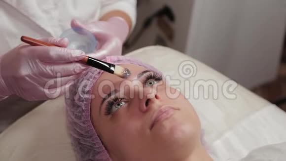 专业美容师用刷子在客户的脸上涂上口罩视频的预览图