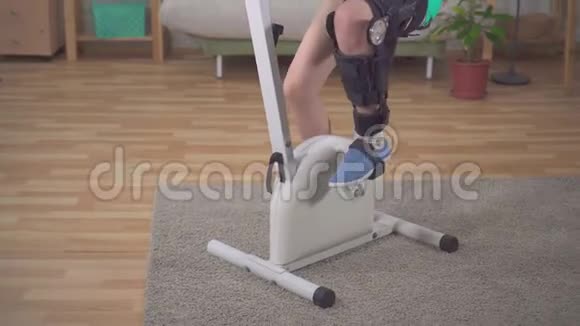 一名亚洲女子膝关节弯曲矫形器受伤后在固定自行车膝关节弯曲矫形器视频的预览图