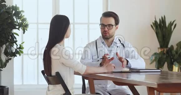 男医生与年轻女性病人进行医疗咨询视频的预览图