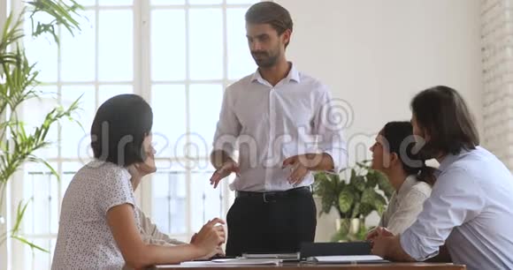 自信的男领导在办公室会议上向业务团队讲话视频的预览图