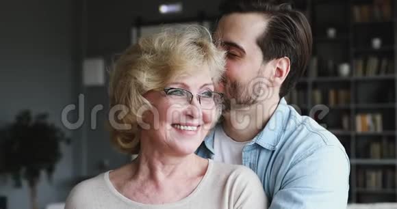 可爱的大儿子拥抱亲吻快乐的大妈妈表达爱意视频的预览图