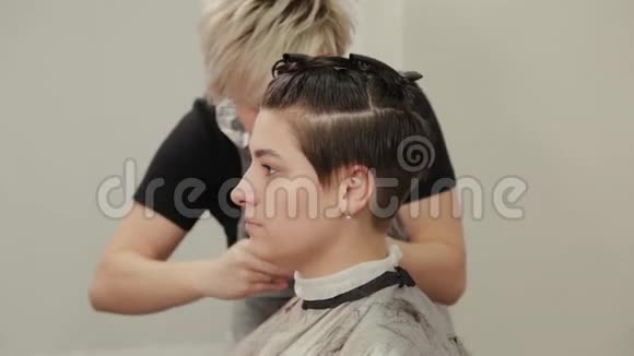 专业的理发师女士在湿发上给客户做发型视频的预览图