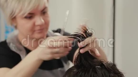 专业的理发师女士在湿发上给客户做发型视频的预览图