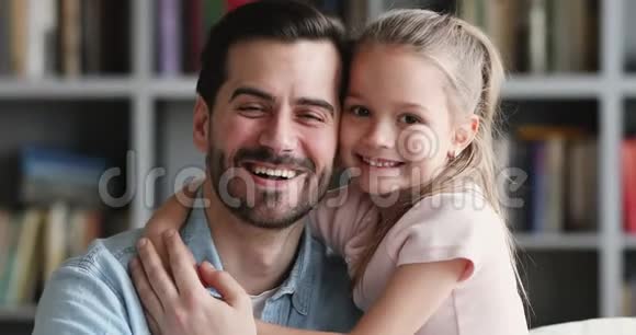 可爱的女儿拥抱快乐的父亲拥抱着看镜头视频的预览图