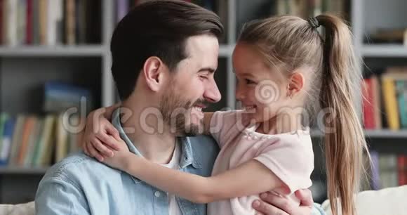 快乐的爸爸和可爱的女儿拥抱着看镜头视频的预览图