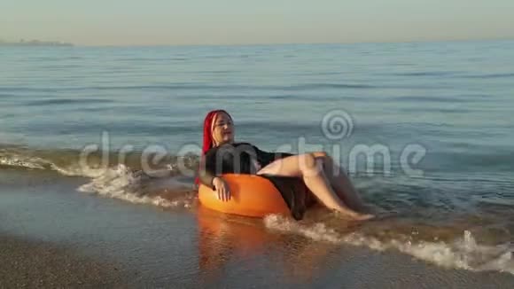 一个穿着泳衣的女人在海浪中游泳在海边晒日光浴视频的预览图
