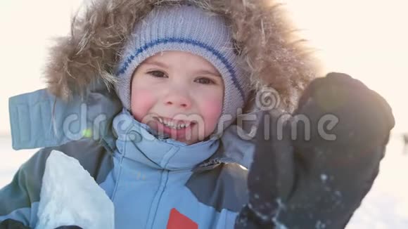 在阳光明媚的日子里快乐的孩子在冬天的公园里开心地笑着冬天的雪景户外视频的预览图