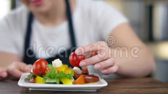 微笑的女厨师把生西红柿放在盘子里做素食沙拉4k红色摄像机特写镜头视频的预览图