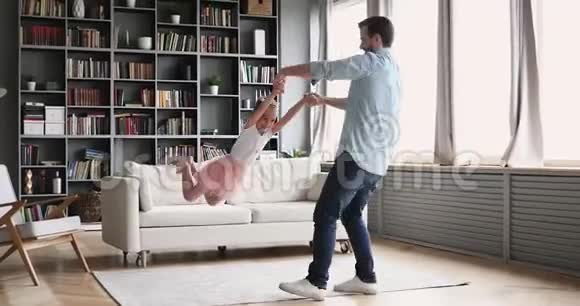可爱的父亲和女儿在家玩旋转游戏视频的预览图