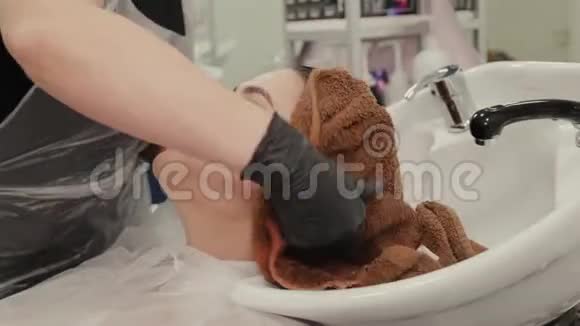专业的理发师女士用毛巾给客户擦头发视频的预览图