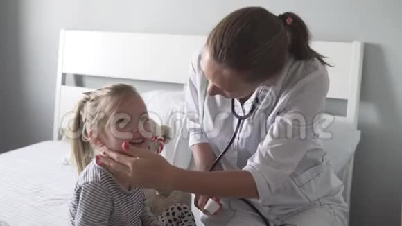 医生用电子温度计测量一个小女孩的体温视频的预览图