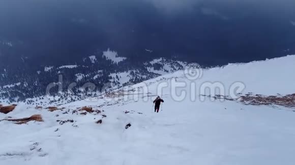 徒步旅行者在冬天爬上山腰视频的预览图