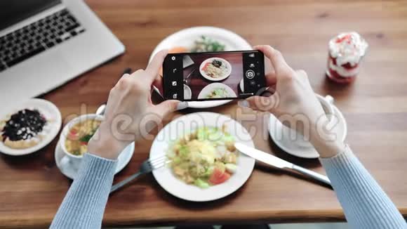 波夫用智能手机拍摄了女性的手在桌子上拍摄食物近距离拍摄4k红色相机视频的预览图