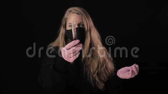 戴着黑色面具的女孩拿着一根带血的试管上面写着Covid19孤立在黑色背景上健康视频的预览图