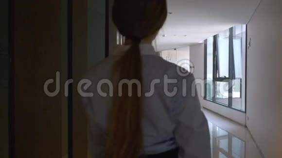 年轻商界女性走在办公楼走廊视频的预览图