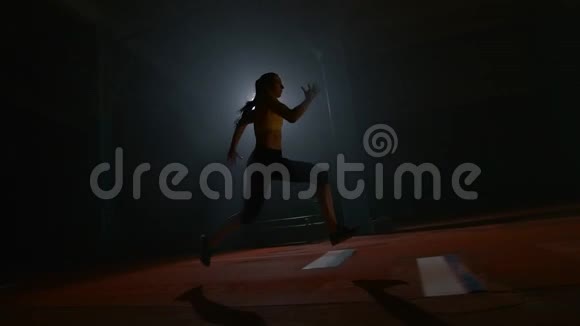 在运动场上跑步的女子运动员在跑步机上进行三级跳跃然后飞进沙场视频的预览图
