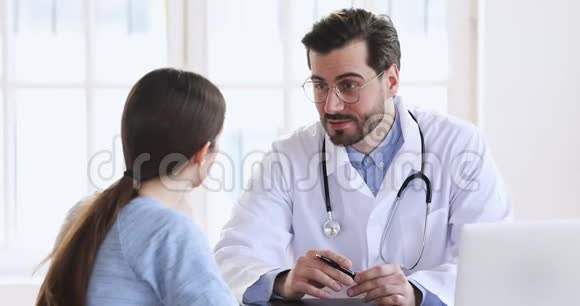 微笑男医生穿白色医疗服咨询女病人视频的预览图