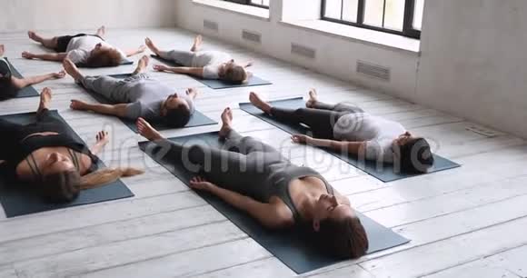 多种族练习瑜伽的人躺在垫子上视频的预览图
