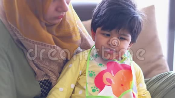 穆斯林母亲在室内喂养婴儿视频的预览图