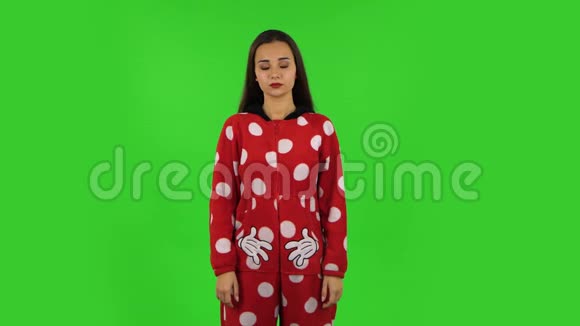 穿红色羊毛睡衣的漂亮女孩在打哈欠睡觉的概念绿色屏幕视频的预览图