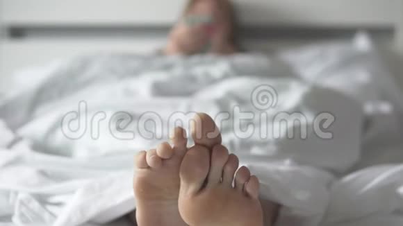 一个女人早上在床上用手机视频的预览图