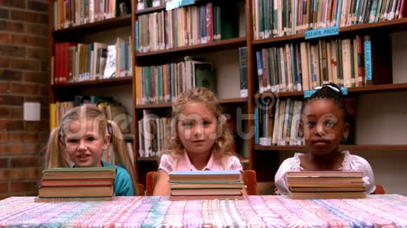 可爱的小女孩摆着图书馆的书视频的预览图