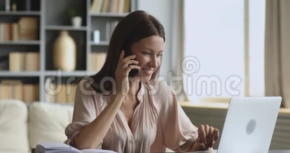 女商人在家里的办公桌上用手提电脑打电话视频的预览图