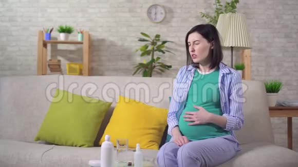 疲惫的孕妇躺在沙发上会感到不适和头痛视频的预览图