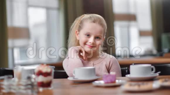 可爱的小孩坐在自助餐厅微笑4K红色相机拍摄视频的预览图