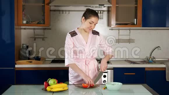 女孩站在桌子上做沙拉切蔬菜视频的预览图